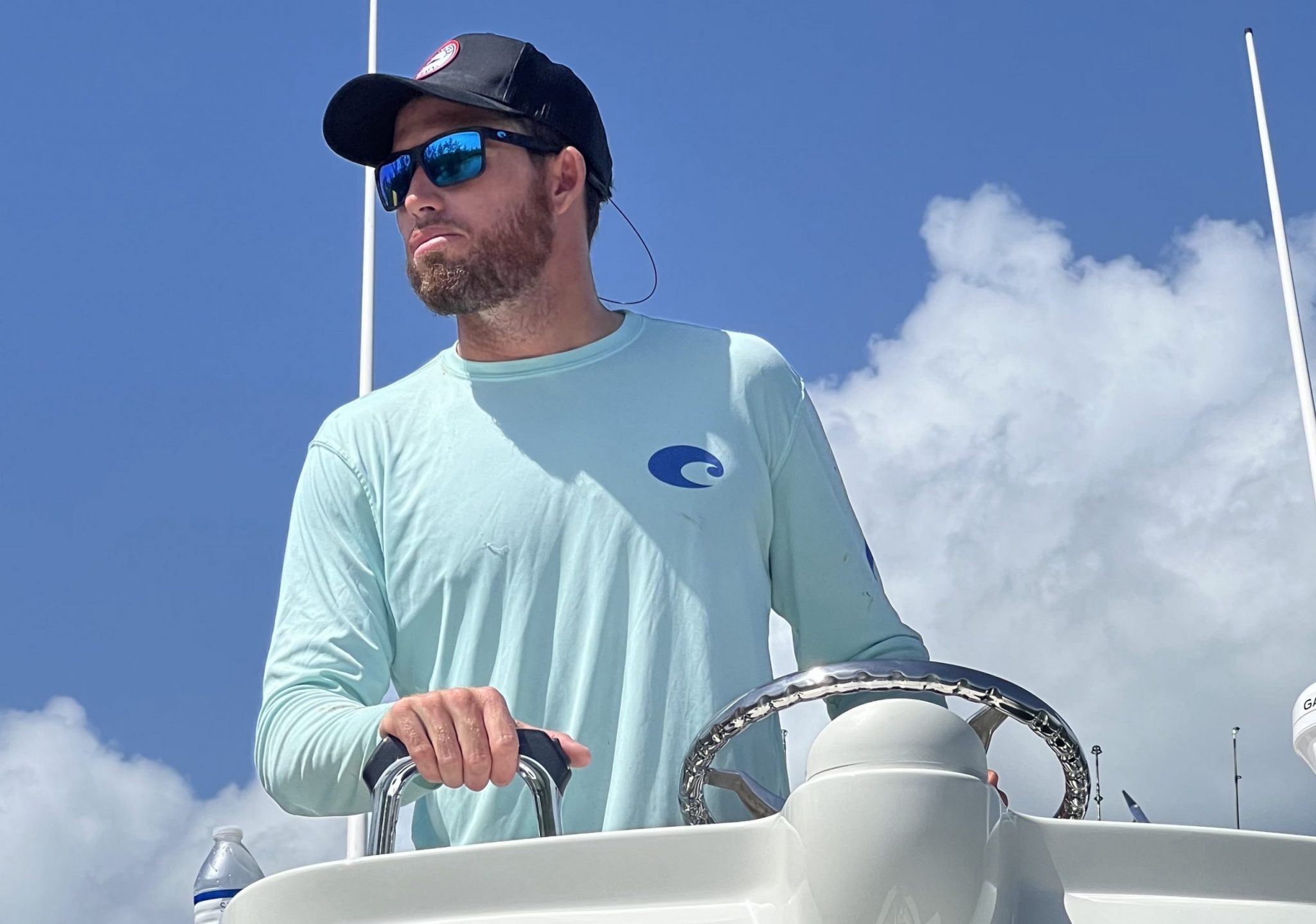 A confident and experienced charter captain standing on a fishing boat, ready to lead a successful fishing expedition.
