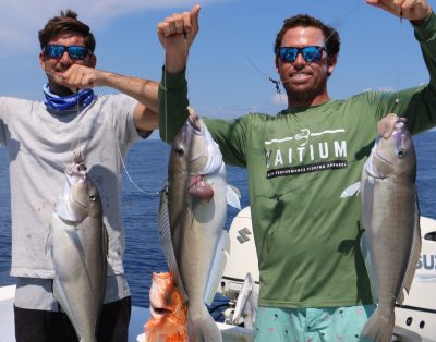 Two charter captains proudly displaying blue tilefish, rosefish, and other deep-sea fishing catches while on a charter trip.