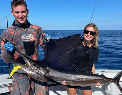 A cute couple holding a sailfish while on a deep-sea fishing charter in Key West, Florida.