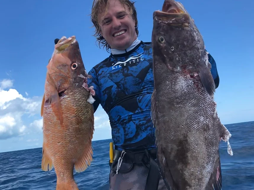 Client proudly displays a snapper and black grouper caught while spearfishing with a speargun in the Florida Keys.