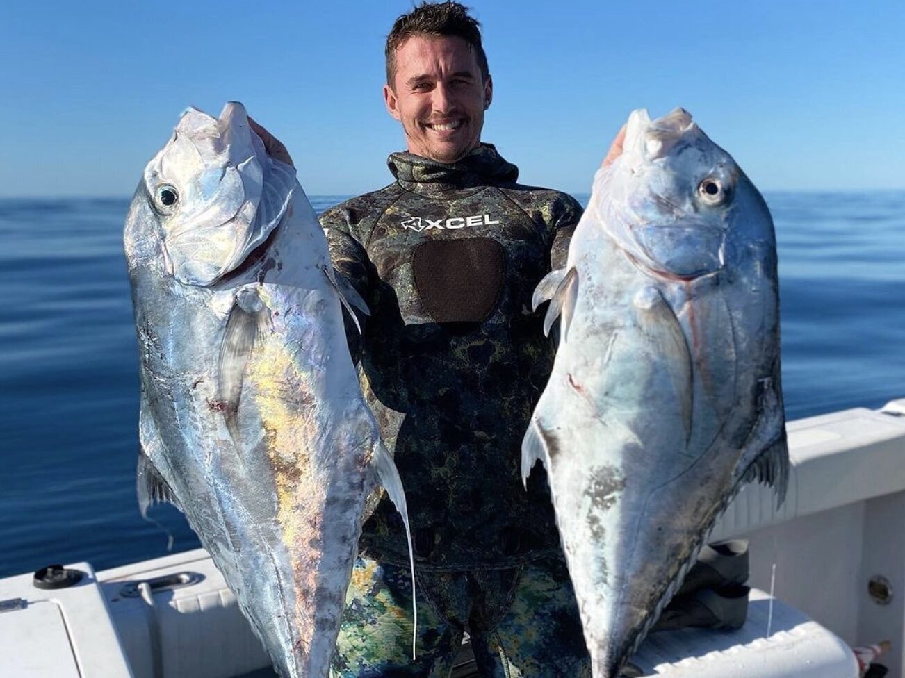 Client proudly displays two African pompano caught while spearfishing with a speargun in Outer Banks, North Carolina.