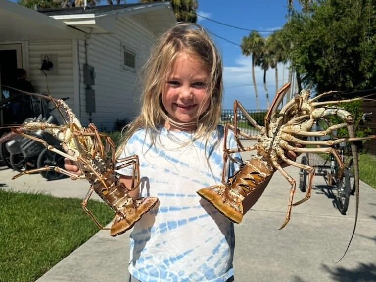 Young girl holding lobsters after bully-netting charter.