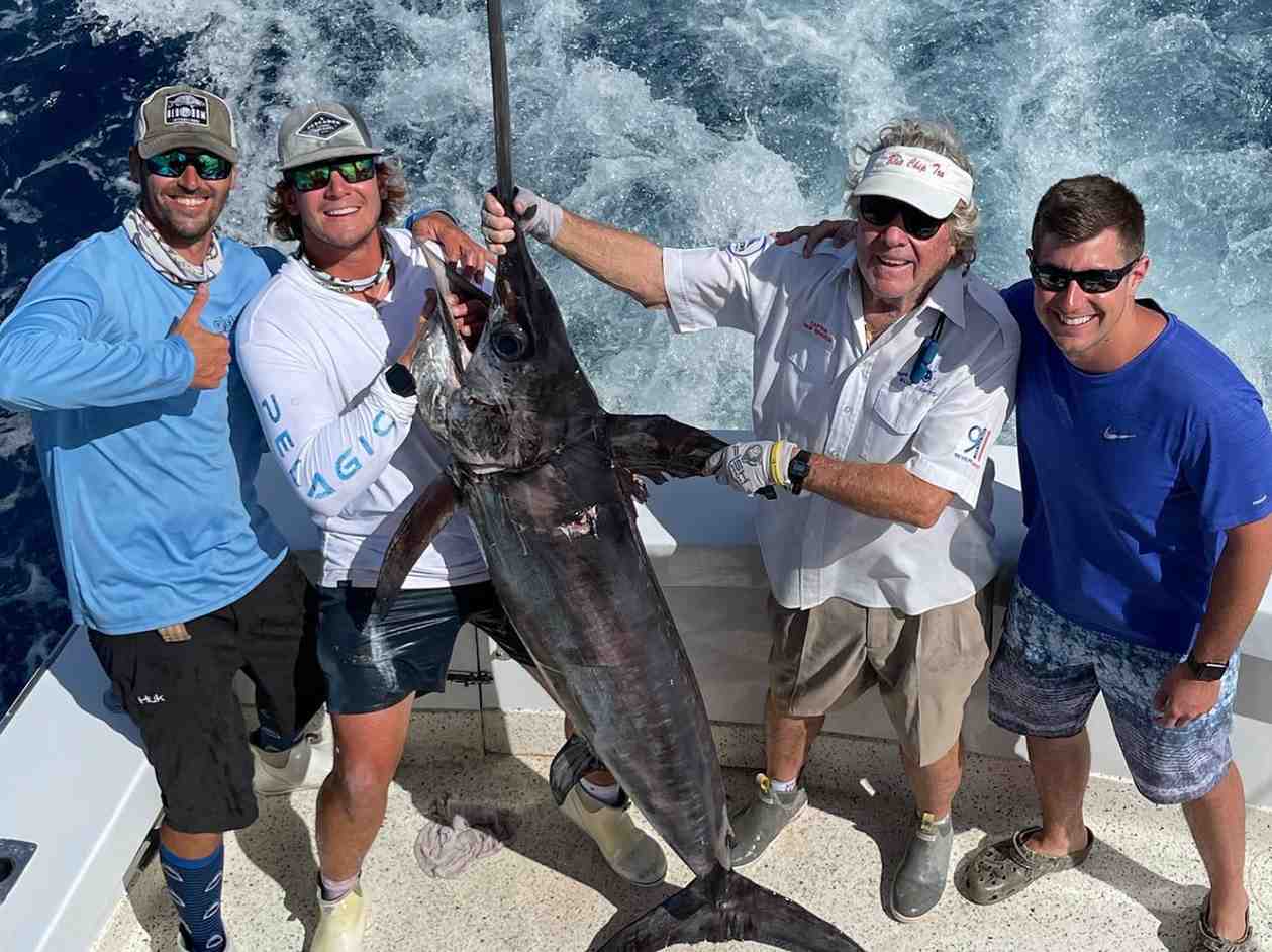 Group of 4 friends holding a giant swordfishing while on a swordfish charter in Florida.