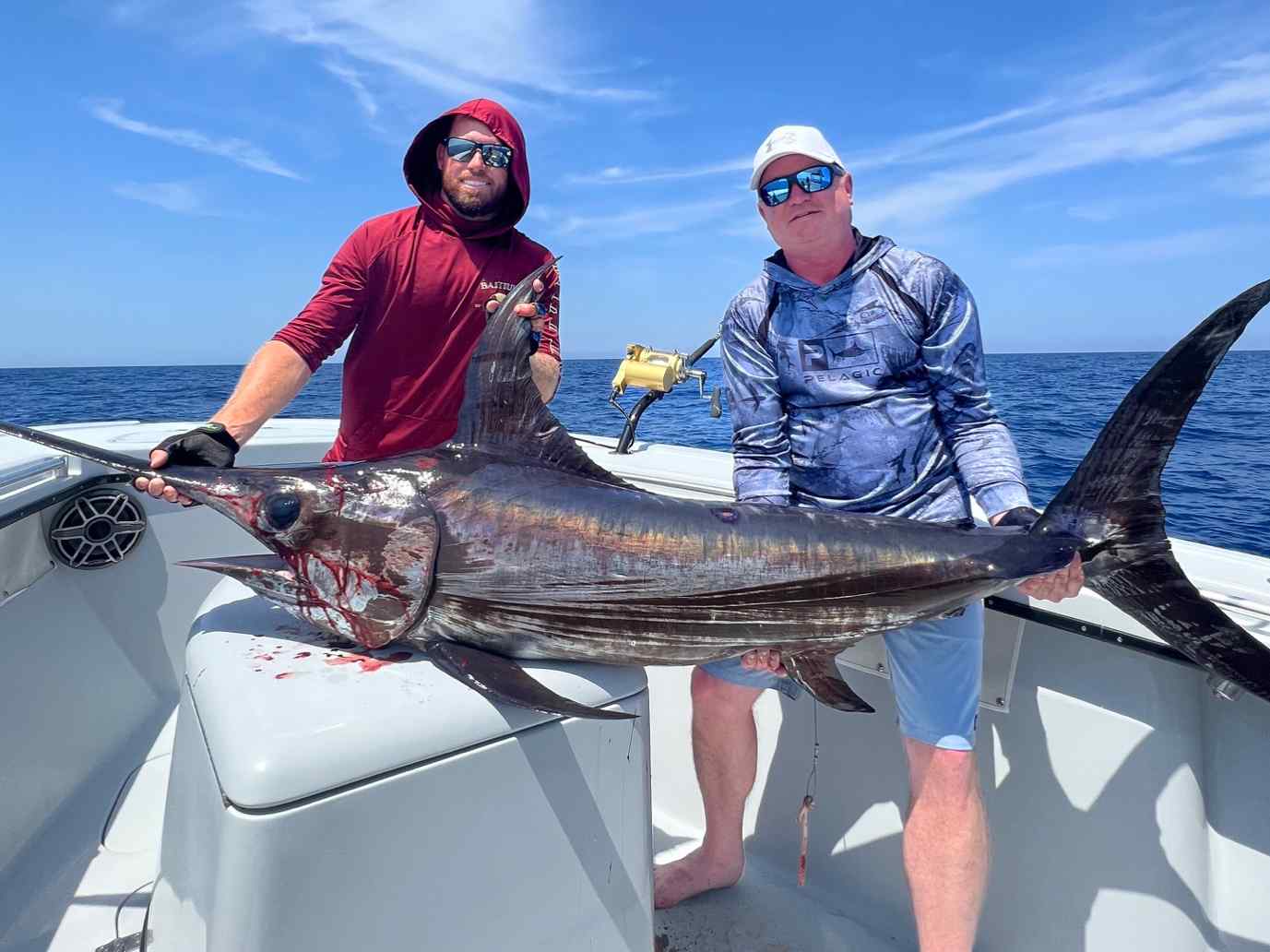 Father and son holding a fish during a swordfishing charter in the Florida Keys.