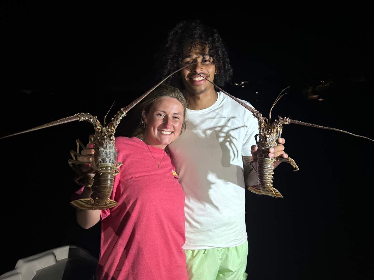 Happy couple holding up lobsters caught during lobster charter in key west.