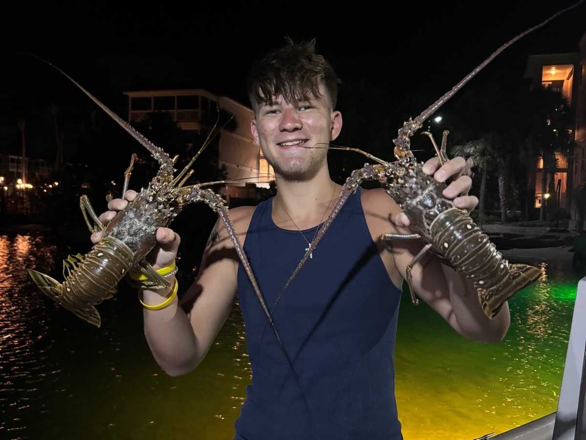 Young man holding a lobster during Lobster fishing in Key West, Florida.