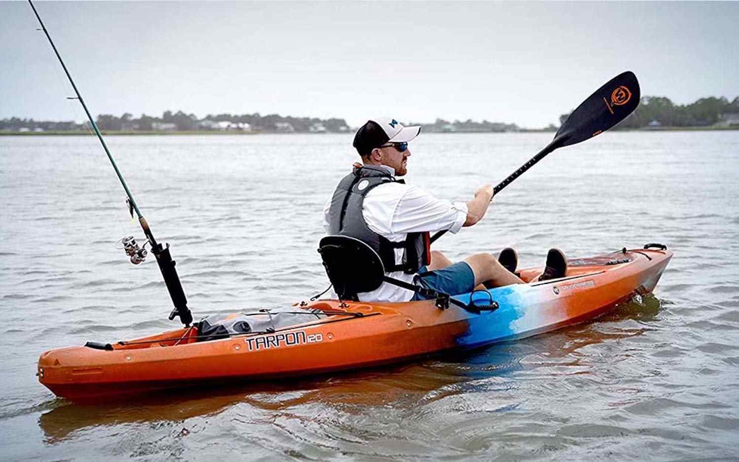 Best Fishing Kayaks Orange Reel Guides Orange fishing kayak on calm water ready for a day of fishing