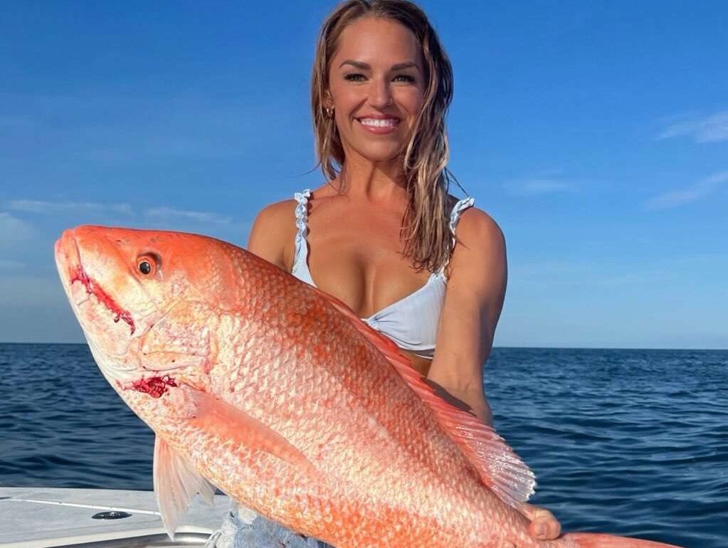 florida keys snapper female angler Reel Guides Female angler proudly displaying a Florida Keys red snapper caught on offshore charter.